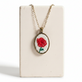 Necklace with a red flower pendant on a white background