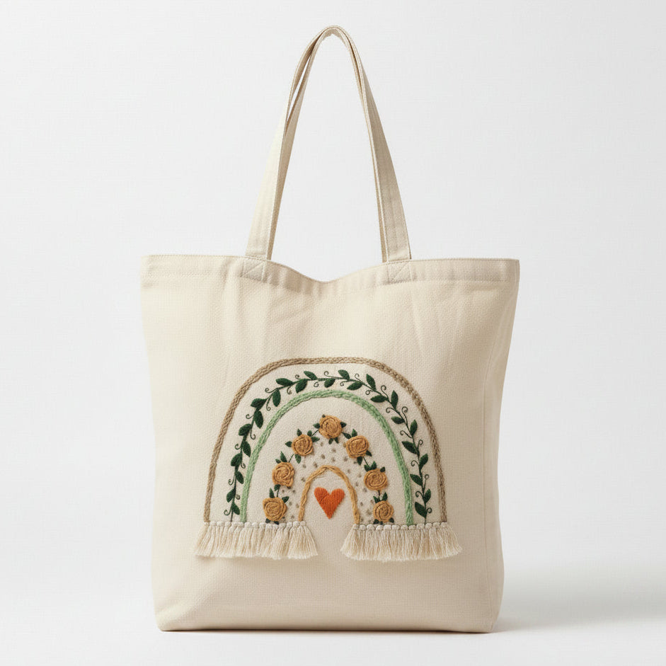 Beige tote bag with embroidered rainbow design on a white background