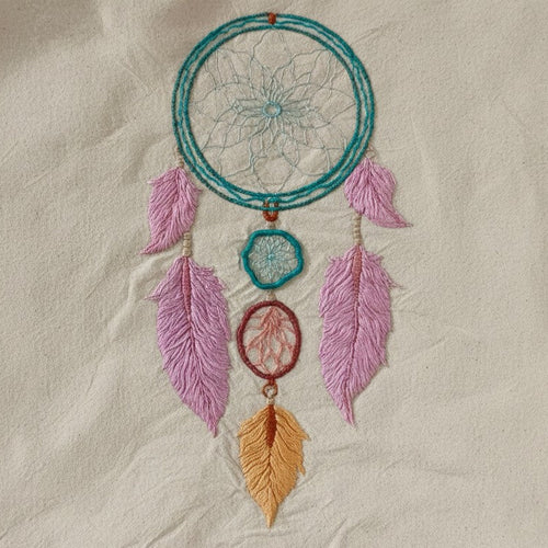 Embroidered dreamcatcher with feathers on a beige fabric background