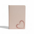 Pink notebook with a heart design on a light beige background