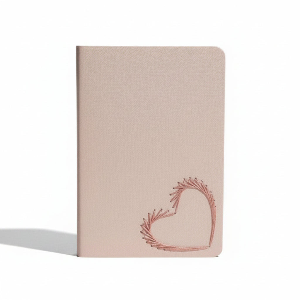Pink notebook with a heart design on a light beige background
